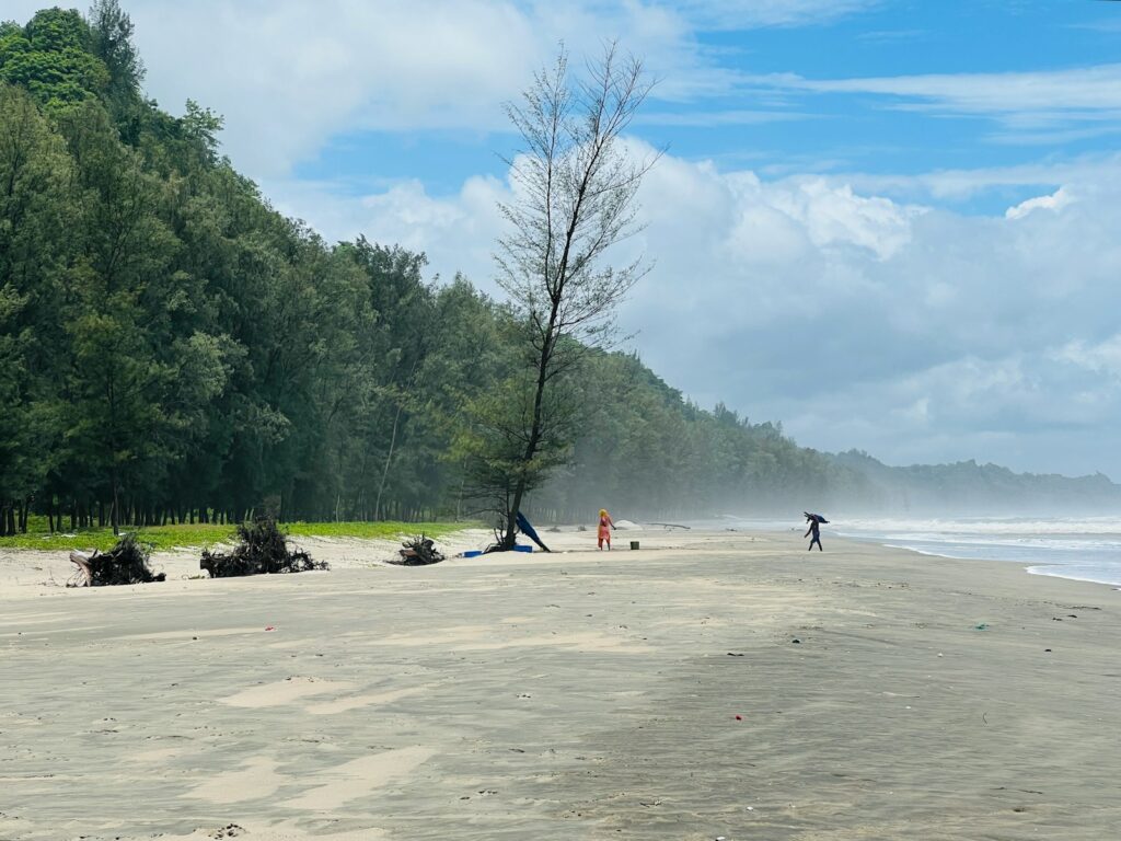 a group of people standing on top of a sandy beach
