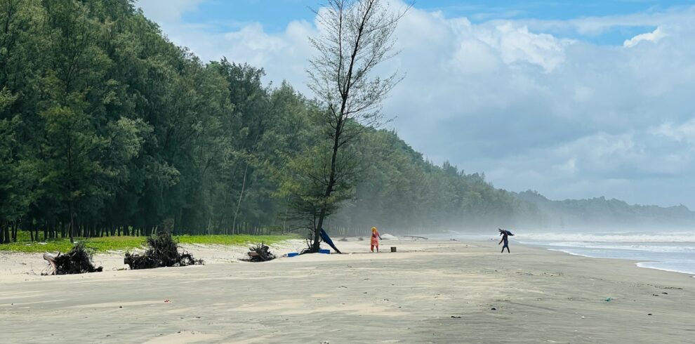 a group of people standing on top of a sandy beach