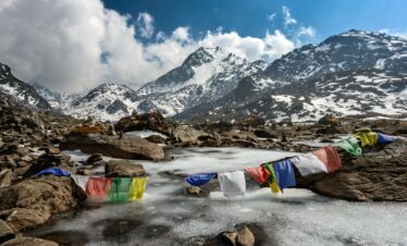 assorted-color of apparel hanged below creek across glacier mountain