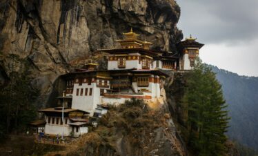 white and brown concrete house on rocky mountain during daytime