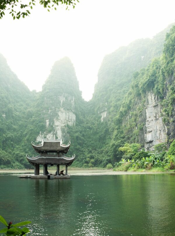 pagoda surrounded by body of water and mountains